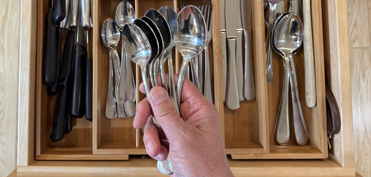 Spoon Theory — the spoon drawer and daily supply of spoons...an overhead shot of Steve's hand holding spoons over an open silverware drawer